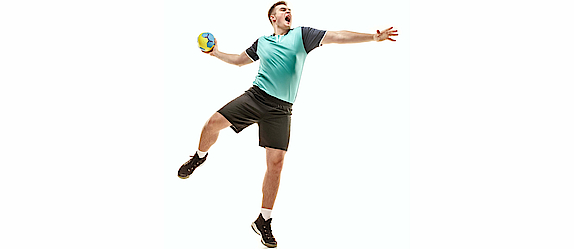Ein Handballspieler in einem türkisfarbenen Trikot ist bereit zu einem Wurf. Der Ball ist in seiner rechten Hand.