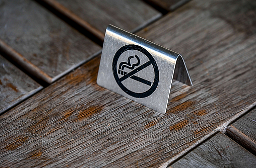Auf einem Holztisch steht ein Nichtraucher-Schild