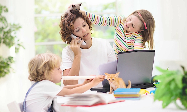 Eine Mutter arbeitet im Homeoffice. Die Tochter spielt mit einem Dinosaurier auf ihrem Kopf. Der Junge spielt Blockflöte. Die Mutter ist genervt, denn sie telefoniert.