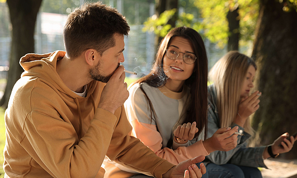 Junge Menschen sitzen und Rauchen