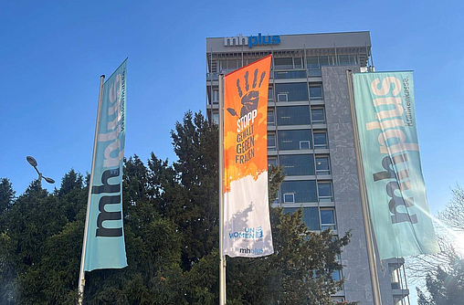 Flagge zu Orange The World weht vor mhplus-Hochhaus in Ludwigsburg neben einer Unternehmensflagge