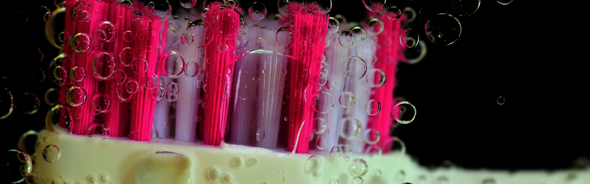 Zu sehen ist eine rosane Zahnbürste mit Blubberblasen.