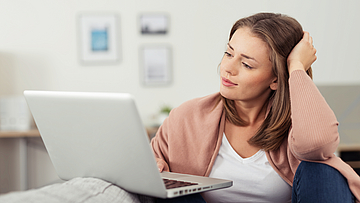 Frau prüft mit Laptop Vergleichsangebote von Ärzten und Zahnärzten.