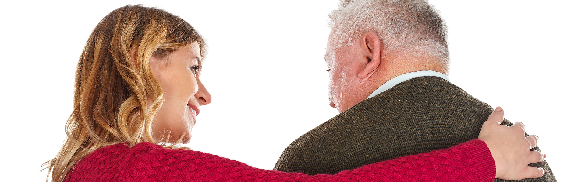 Frau und älterer Mann stehen mit dem Rücken zum Bild. Die Frau umarmt den Mann.