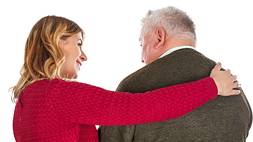 Junge Frau pflegt einen älteren Mann.