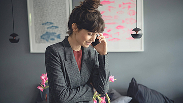 Geschäftsfrau sitzt im Büro und telefoniert.