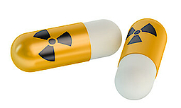 Zwei gelb-weiße Pillen mit dem Symbol für Radioaktivität auf weißem Untergrund.