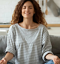 Junge Familie mit kleiner Tochter versuchen eine Yoga Entspannungsübung auf einem Sofa.