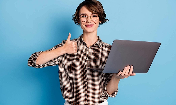 Digitale Kompetenz Gesundheit - Frau Daumen nach oben Eine Frau hält einen Laptop in der Hand. Sie hält den rechten Daumen nach oben und freut sich.