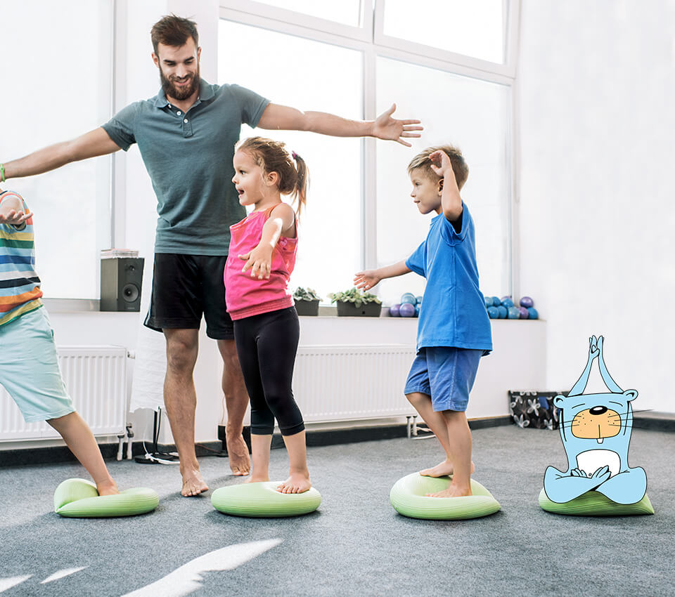 Ein Mann macht Sport mit kleinen Kindern und PFIFFIX auf Yoga-Steinen.